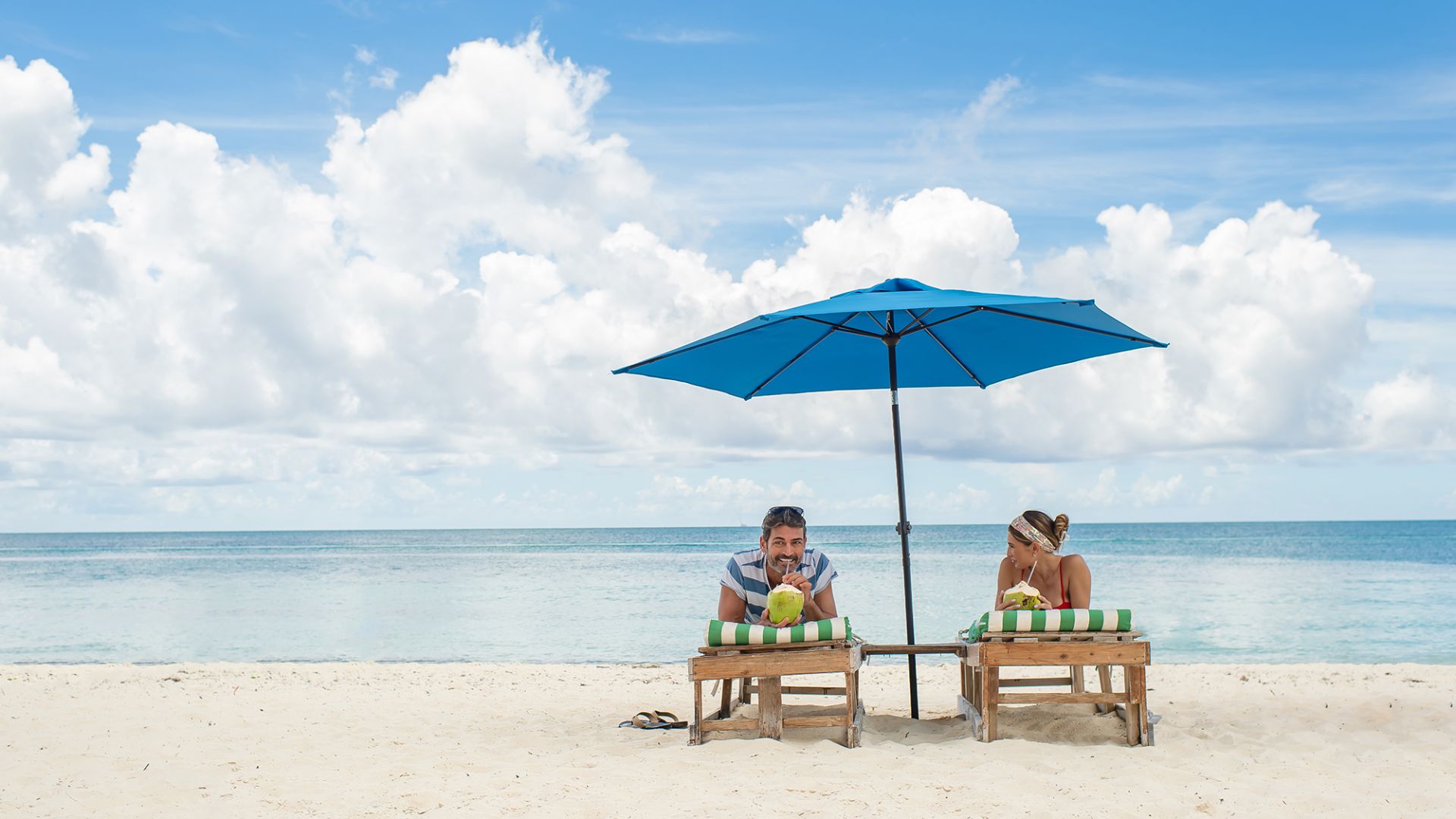 Neil Malik Abdullah Et Al. Sit Under An Umbrella On A Beach