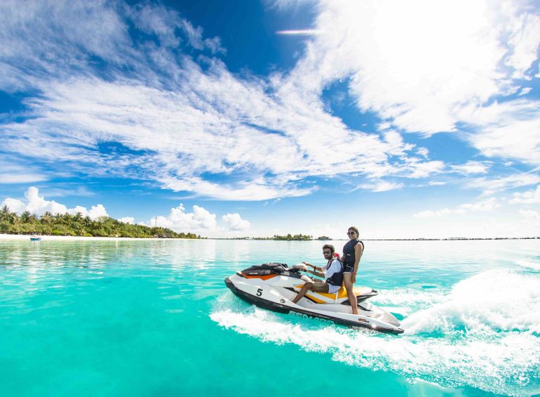 A Man And A Woman On A Jet Ski In The Water