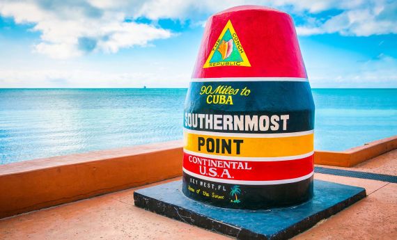 A Colorful Container On A Dock With Southernmost Point Buoy In The Background