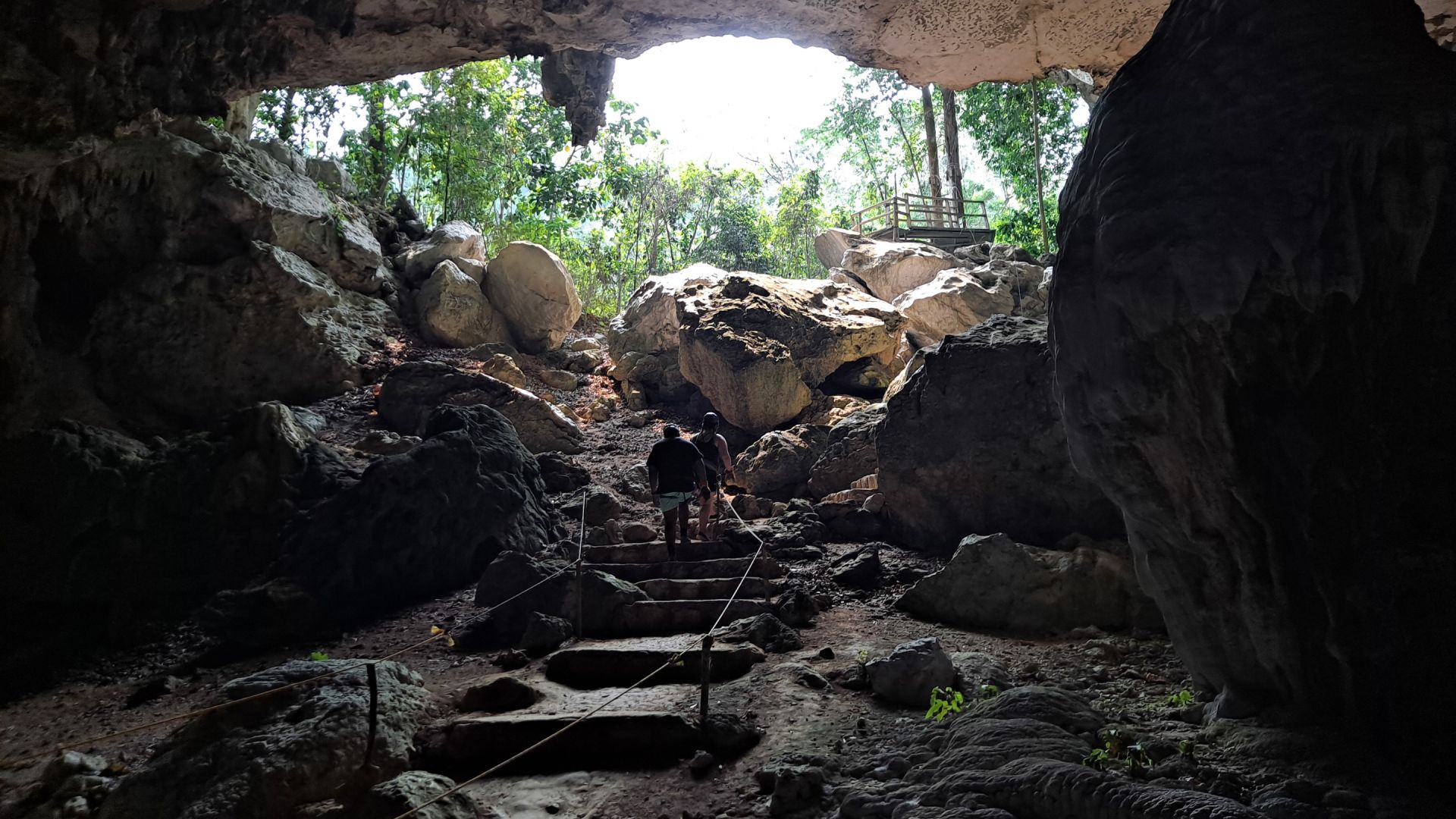 A Group Of People Walking Through A Cave
