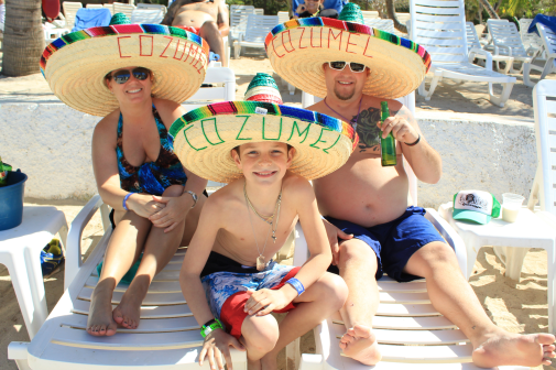 A Group Of People Wearing Sombreros And Sitting On A Beach